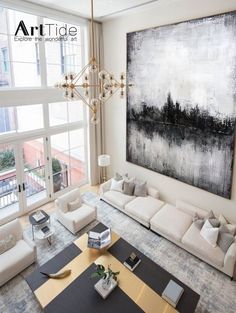 a living room filled with lots of furniture and a large painting on the wall above it