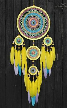 a yellow and blue dream catcher hanging on a wooden fence