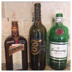 three different types of wine bottles on a counter top with numbers and names in the upper left corner