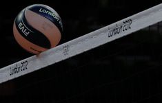 a volley ball sitting on top of a net in front of a black background with the words london written across it