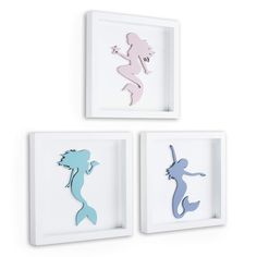 three framed silhouettes of mermaids in different colors and sizes, one is white the other is blue