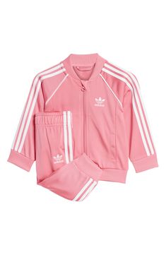 Start your little one off right in this sporty and sustainable track suit cut from recycled-polyester tricot and marked with all the classic adidas details. Jacket has front zip closure; welt pockets Bottoms have elastic waist 100% recycled polyester Machine wash, tumble dry Imported Pink Athleisure Activewear With Ribbed Cuffs, Pink Long Sleeve Tracksuit For Jogging, Pink Athleisure Tracksuit For Jogging, Pink Adidas Sporty Activewear, Pink Sportswear Tracksuit For Jogging, Pink Sportswear Tracksuit For Sports, Pink Sportswear Tracksuit, Spring Pink Activewear For Jogging, Pink Fitted Tracksuit For Sports