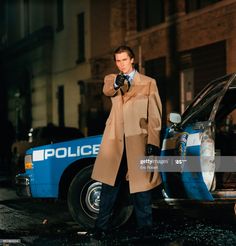 a man standing next to a police car