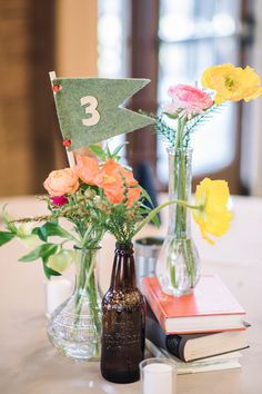 vases with flowers and books on a table