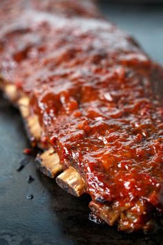 ribs covered in bbq sauce sitting on top of a grilling pan, ready to be cooked