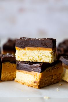 several pieces of cake are stacked on top of each other with chocolate and peanut butter