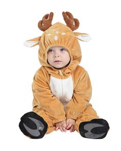 a baby wearing a deer costume sitting on the ground