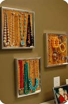 there are three pictures hanging on the wall with beads and necklaces attached to them