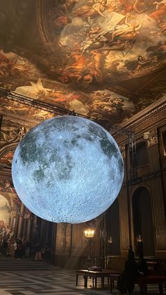 an artist's rendering of the moon hanging from the ceiling in a room with paintings on it