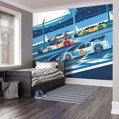 a child's bedroom with cars painted on the wall and bed in the foreground