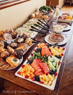 a long table filled with lots of different types of desserts and pastries on it