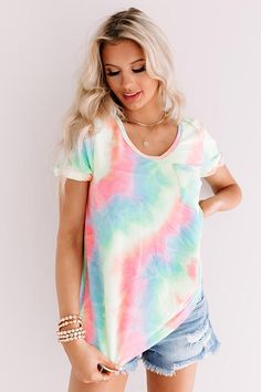 Steal the show with our vibrant "Mai Tai Time" tee featuring soft lightweight material patterned with neon pink, blue, yellow, and green tie dye, a scooped neckline that can be worn off one shoulder, short loose sleeves with tolled cuffs, an accent chest pocket, and a relaxed silhouette that falls into a rounded hemline that can be knotted! We have styled this summer cutie with some distressed denim shorts and trendy sneakers, but you can also wear it with some white flares, clear sandals, and a