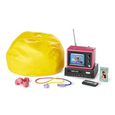 an old fashioned tv and some toys on a white surface with a yellow bean bag