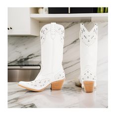 Shyanne Women's Danitza (Snip Toe) Western Boots Medium Sizes in a stunning solid white design. These eye-catching boots feature intricate details and classic Western elements that will elevate your cowgirl style to new heights. Crafted from high-quality leather, these boots boast a snip toe design that adds a touch of elegance and sophistication to your ensemble. The 13" shaft height offers ample coverage and support for your legs, while the pull tabs ensure easy on and off for added convenienc White Western Heeled Boots For Fall, White Western-style Fitted Heeled Boots, White Fitted Western-style Heeled Boots, White Knee-high Boots With Wide Calf, White Wide Calf Knee-high Heeled Boots, White Knee-high Boots For Wide Calves, Trendy White Knee-high Heeled Boots, White Knee-high Medium Width Heeled Boots, Trendy White Pointed Toe Mid-calf Boots