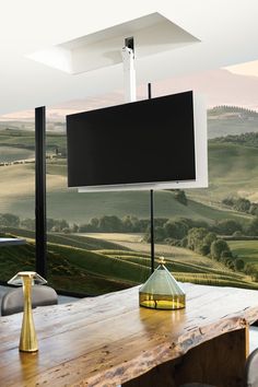 a wooden table sitting in front of a flat screen tv on top of a wall