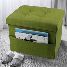 a green ottoman sitting on top of a rug next to a pair of slippers