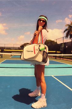 a woman holding a tennis racquet on top of a tennis court