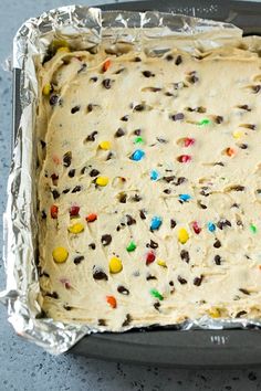 an uncooked cake with sprinkles and chocolate chips on it in a pan