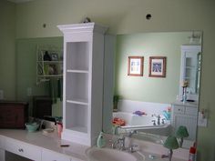 a bathroom with a sink, mirror and cabinets in it's centerpieces