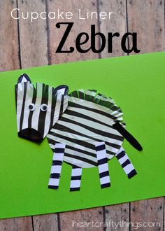 a zebra made out of paper sitting on top of a green board with the words cupcake liner zebra