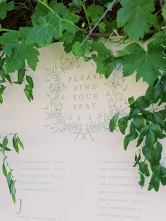 a close up of a leafy plant near a sign with writing on it that says please find your seat