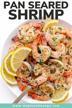 a white plate topped with shrimp and lemon wedges