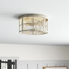 a light fixture hanging from the ceiling in a room with white walls and wood paneling