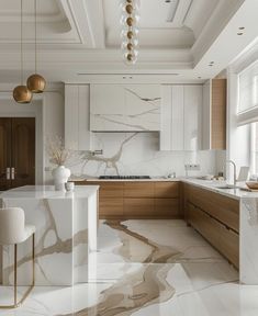 a kitchen with marble counter tops and white cabinets, along with gold pendant lights hanging from the ceiling