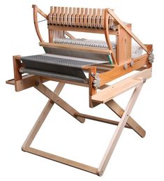 an old weaving machine sitting on top of a wooden stand with two rows of yarn