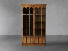 an old wooden bookcase with glass doors on the front and bottom, against a gray background