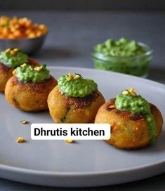 some food is sitting on a white plate with green sauce and guacamole