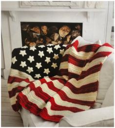 an american flag blanket sitting on top of a white chair next to a fire place