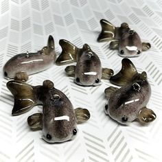 small ceramic fish sitting on top of a white surface