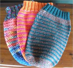 three knitted bags sitting on top of a wooden table