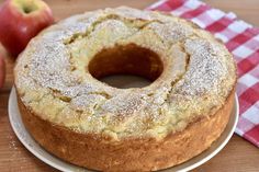 a cake sitting on top of a white plate next to an apple