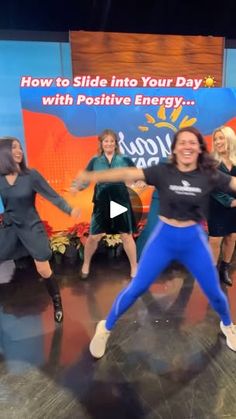 a group of women dancing on stage in front of a sign that says, how to slide into your day with positive energy