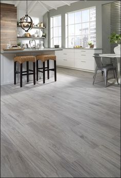 a kitchen with two stools in front of the counter and an island behind it