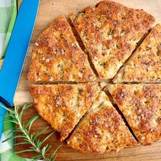 a sliced pizza sitting on top of a wooden cutting board next to a knife and fork