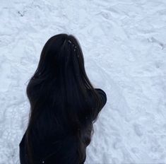 a woman standing in the snow with her back to the camera