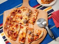 a pizza cut into eight slices on a cutting board with a spatula and spoon