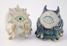 two ceramic figurines with different designs on them, one in the shape of an eye