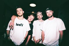 three men standing next to each other wearing levi's t - shirts