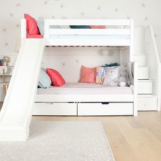 a white bunk bed with a slide next to it in a child's room