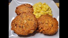 three crab cakes and scrambled eggs on a white plate