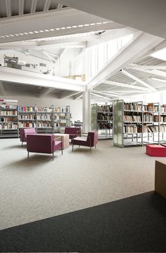 an empty library with chairs, tables and bookshelves in the middle of it