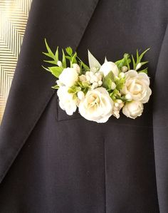 a man in a suit with white flowers on it's lapel flower pin