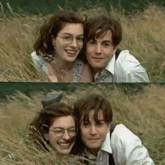 two people laying in the grass with their arms around each other and one person smiling at the camera