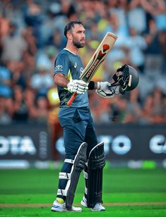 a man holding a cricket bat on top of a field