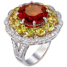 Bright colors and multiple spinning motifs create an energizing and fun jewel that can make any day brighter. An 8.38-carat round Spessartite Garnet is surrounded by a row of round 3.40-carat Yellow Sapphires which is surrounded by round 0.63-carat White Diamonds. All of these gems and more are set on a well-crafted 18K Gold ring. This ring, as with all Zorab Creation pieces, are sent with a unique serial number to validate its authenticity. Ring Size 7.5 Luxury Round Gemstones For Anniversary, Luxury Multicolor Round Topaz Ring, Yellow Multi-stone Round Gemstones, Elegant Multicolor Ruby Ring, Multi-stone Round Sapphire Ring In Platinum, Luxury Round Yellow Gemstones, Luxury Yellow Round Gemstones, White Gold Multi-stone Round Sapphire Ring, White Gold Sapphire Ring With Multi-stone