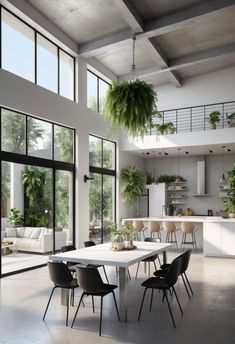 a dining room table with chairs and plants hanging from it's ceiling in front of large windows